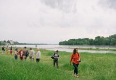 sur le site naturel de la confluence à Candes-Saint-Martin, des personnes en groupe longe la Loire après avoir profité d'un atelier sur les paysages du Parc