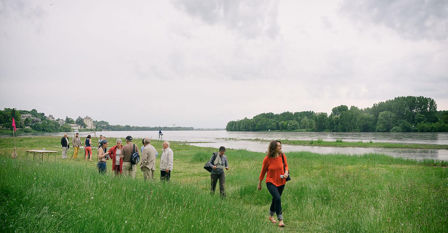 sur le site naturel de la confluence à Candes-Saint-Martin, des personnes en groupe longe la Loire après avoir profité d'un atelier sur les paysages du Parc