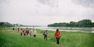 sur le site naturel de la confluence à Candes-Saint-Martin, des personnes en groupe longe la Loire après avoir profité d'un atelier sur les paysages du Parc