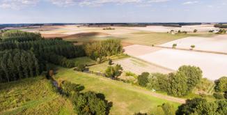 paysage agricole composé de petits boisements au bord d'un cours d'eau et de champs cultivés en céréales©N. Van Ingen_propriété du Parc naturel régional utilisation interdite