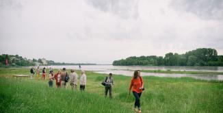 sur le site naturel de la confluence à Candes-Saint-Martin, des personnes en groupe longe la Loire après avoir profité d'un atelier sur les paysages du Parc